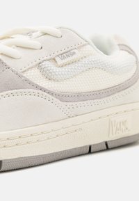 Sneakers Vans z połączeniem jasnobeżowego zamszu i siateczki, z białą gumową podeszwą i teksturowanymi detalami.