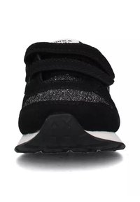 Sneaker nera con una combinazione di parte superiore in suede e mesh. Dotata di cinturini in Velcro, suola nera testurizzata e un accento bianco sul tallone.