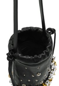 Czarna skórzana torba typu bucket z zebranym dnem, zdobiona metalowymi koralikami w złotym i srebrnym kolorze, z ściągaczem i paskiem na ramię.