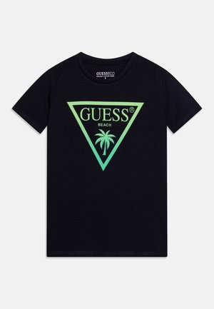 Schwarzes T-Shirt mit kurzen Ärmeln und grünem Dreieckslogo, das die Wörter "GUESS", "BEACH" und eine Grafik mit einer Palme zeigt.
