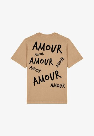 T-shirt en coton beige avec du texte noir qui épelle "AMOUR" dans diverses tailles et orientations au dos.