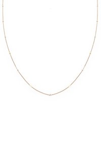 Guldtonet halskæde med en delikat kæde, der har vekslende runde perler og små krystaller, hvilket skaber en subtil glans.