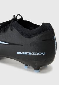 Crampons de football noirs avec une tige synthétique texturée, des lacets plats et un marquage 'AIR ZOOM' en bleu clair. Studs coniques visibles sur la semelle.