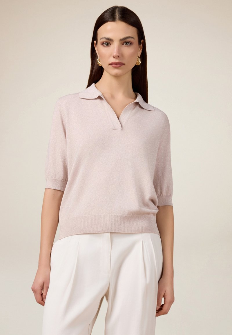 Helles rosa Kurzarm-Pullover mit Kragen, aus weichem, strukturiertem Stoff. Verfügt über einen lockeren Schnitt und gerippte Säume.