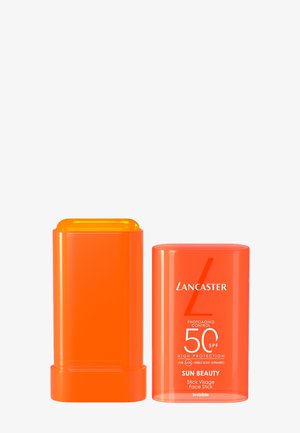 Orange Lancaster Sun Beauty SPF 50 ansigtssolscreen stick med afmonteret låg, der viser det gule produkt indeni.