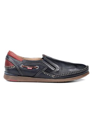 Chaussure noire en cuir à enfiler avec des accents rouges, des coutures décoratives, une semelle en caoutchouc marron et des œillets sur le côté pour la ventilation.