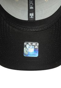 Cappello nero 9FOR con visiera piatta. Presenta un tessuto testurizzato e un'etichetta olografica NFL che mostra il logo e i dettagli del prodotto.