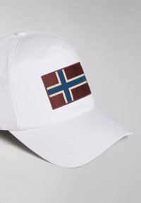 Cappello bianco con un rettangolo bordeaux che presenta un motivo a bandiera blu e crema. Il cappello ha una visiera curva e cuciture visibili.