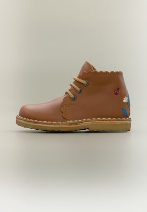 Bruine leren enkellaars met gekartelde randen, beige veters en geborduurde lieveheersbeestje- en bloemmotieven op de hiel.