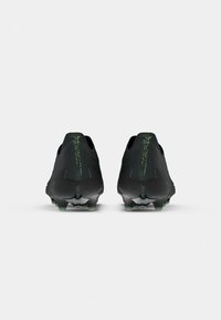Crampons de football noirs avec une tige texturée, des accents verts et un design élégant. Comprend des éléments de talon distincts et des éléments de traction en dessous.