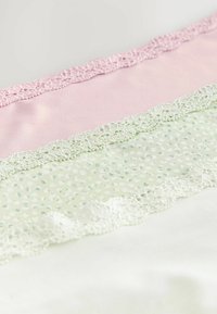 Kolm pitsäärtega kangast lint: roosa, helesinine pusletäkkidega ja valge; siledad tekstuurid ja peened pitsidetailid.