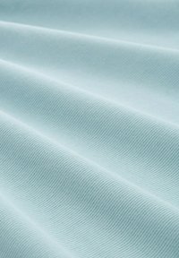 Helles blaues, strukturiertes Gewebe mit diagonalem Rippenmuster, das sanfte Wellen und eine glatte Oberfläche zeigt. Geeignet für Bekleidungs- oder Polsteranwendungen.