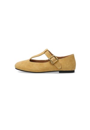 Lichtbruine suède platte schoen met T-strap en goudkleurige rechthoekige gesp, zwarte zool, afgeronde neus, zijaanzicht op witte achtergrond.