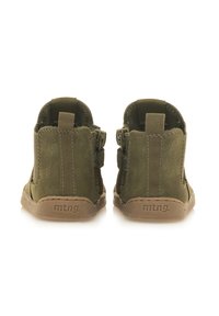 Botas de tobillo de ante en verde oliva con una textura suave, tirantes laterales dobles y suela de goma marrón; presenta el logotipo "mtng." en el tacón.