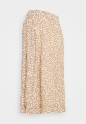 Jupe beige avec une texture douce, arborant un motif léopard en blanc cassé. Taille élastique et un design fluide avec un détail au bas.