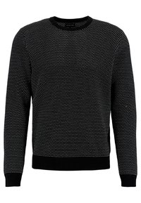 Maglione nero con un motivo testurizzato di piccole macchie bianche, colletto e polsini a costine, e orlo dritto. Realizzato in tessuto lavorato a maglia.