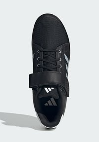Black athletic shoe with a textured upper, featuring a wide strap and white accents. Includes laces and a padded collar for comfort.