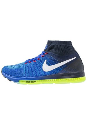 Chaussure de course montante Nike bleue et noire avec un swoosh blanc, des œillets rouges pour les lacets et une semelle Nike Zoom Air jaune vif.