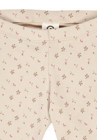 Leggings di cotone in beige chiaro con un motivo floreale ripetuto in rosa e marrone, dotati di una comoda banda elastica in vita.