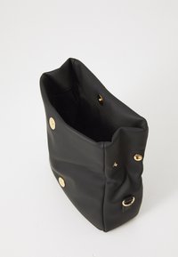 Black soft leather handbag with gold snap button closures, a D-ring attachment, and an open top showing a smooth inner lining.