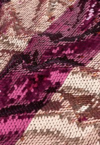 Tyg med överlappande paljetter i nyanser av rosa, mauve och beige, som skapar ett texturerat, vågigt mönster med reflekterande egenskaper.