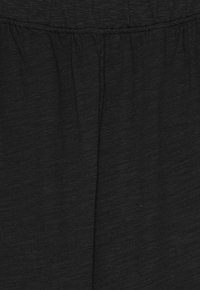 Fekete szövet puha textúrával, összehúzott gumis derékrésszel és finom vízszintes vonalakkal az anyag egészén.