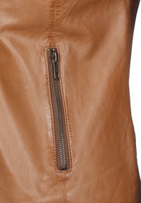 Tan leren stof met een zijrits en metalen tanden. Gladde textuur met zichtbare stiksels langs de randen.