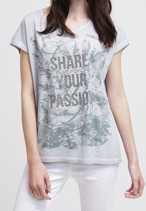 T-shirt a maniche corte grigio chiaro con la scritta "CONDIVIDI LA TUA PASSIONE" stampata in grigio scuro, caratterizzato da un design a foglia e accenti di luccichio sottili.