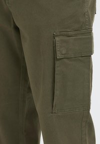 Oliivinvihreät puuvillaiset cargo-housut, joissa on sivutasku ja sileä pinta, vahvistetut saumat ja suorat lahkeet.
