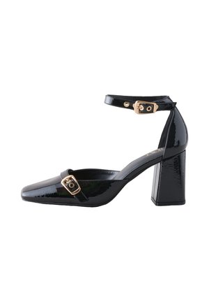 Mustast lakknahast kingad ruudukujulise varbaosaga, plokk-kontsaga, pahkluu rihmaga ja rihmal kuldse tooniga pandlaga. Ühtlane sile tekstuur üle kogu pinna.