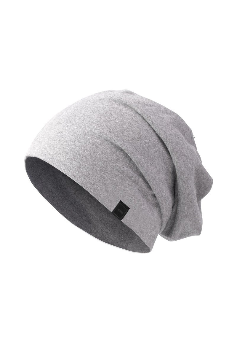 Gorro gris tipo slouch hecho de tela suave, con un dobladillo y una pequeña etiqueta negra en el lado, diseñado para un ajuste holgado.