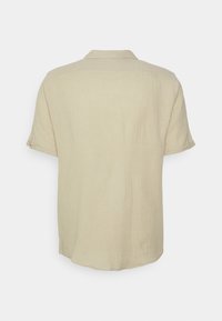 Lichtbeige shirt met korte mouwen, een kraag en een gestructureerde stof. De achterkant heeft een rechte zoom en een minimalistisch ontwerp.