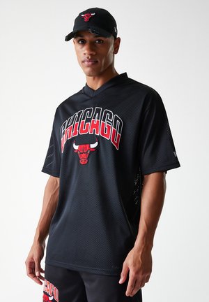 Must mustrikang spordijerseys mustrik, millel on punases kirjas "CHICAGO" ja pulli logo. Kandmisega koos sobiva musta mütsiga, millel on pulli sümbol.