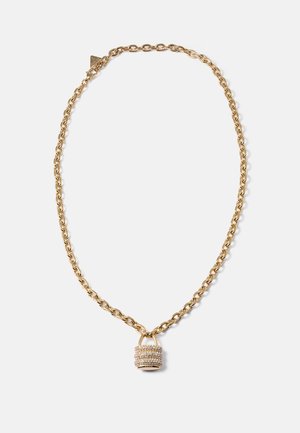 Gouden ketting met een klein hangslot hanger bezet met heldere rhinestones op een lichtgrijze achtergrond.