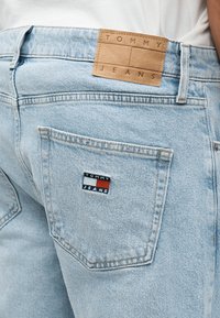 Φωτεινό γαλάζιο τζιν με δερμάτινο ταμπελάκι και κεντητό λογότυπο που γράφει "Tommy Jeans" στην πίσω τσέπη.