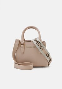 Mazs bēšs rokassoma ar zelta logo "VALENTINO," kas aprīkota ar augšējiem rokturiem un regulējamu auduma siksnu ar logo detaļām. Gluda tekstūra.