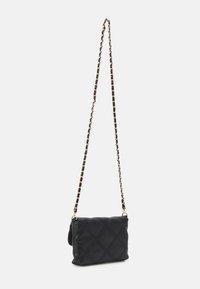 Pehmeä musta nahkainen hihainen olkalaukku, jossa tikattu timanttikuvio ja suorakaiteen muoto. Laukku on lukittavissa kultaisen sävyn metalliosilla.