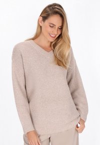 Pulover tricotat bej, cu decolteu în V, croială lejeră, mâneci lungi, model texturat, manșete și tiv cu striații, material moale.