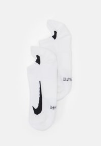 Białe skarpetki sportowe z czarnym logo Nike, charakteryzujące się prążkowaną teksturą i bezszwowym palcem. Niski krój zapewniający osłonę kostki.