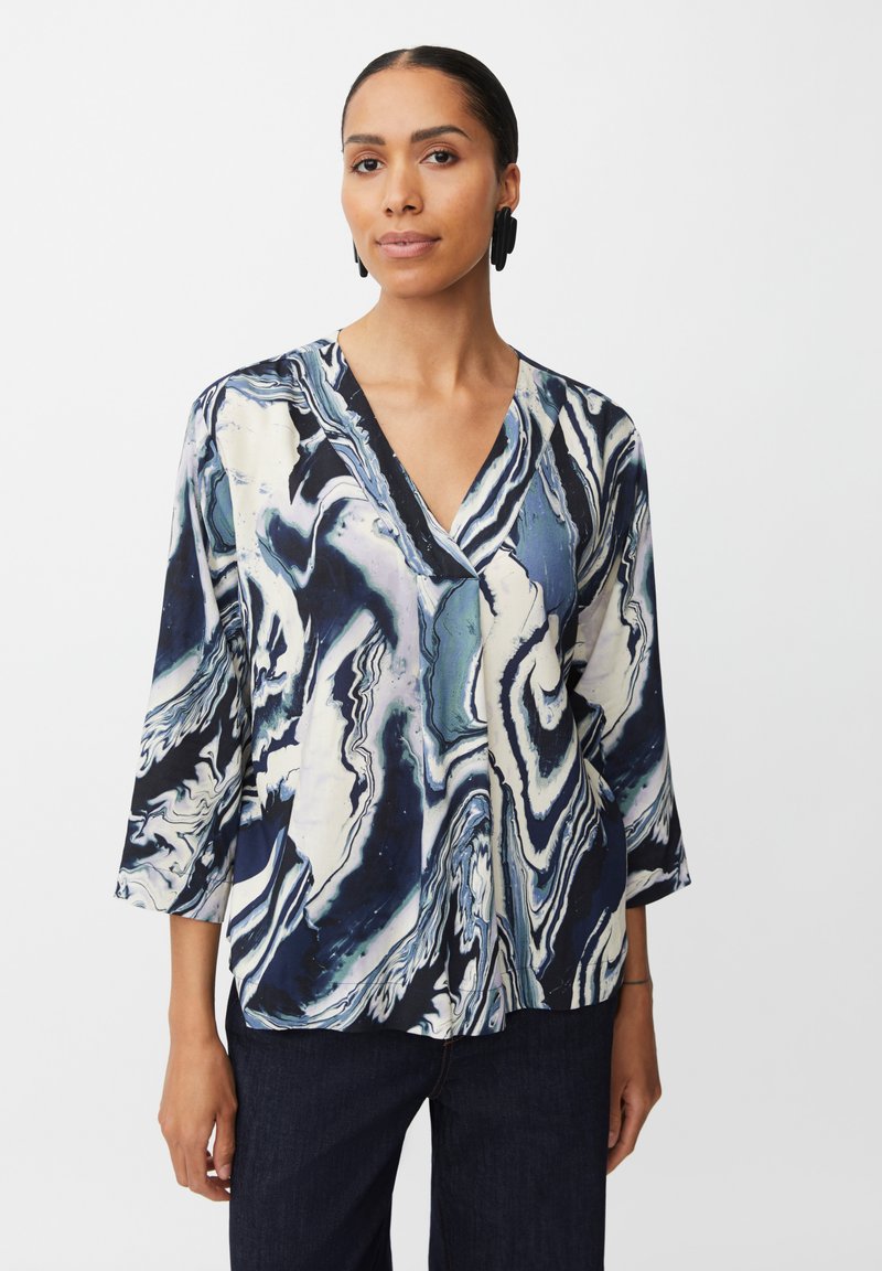 Blusa multicolore con scollo a v in un fluido motivo marmorizzato con tonalità di blu navy, bianco e teal; maniche a tre quarti con vestibilità morbida.