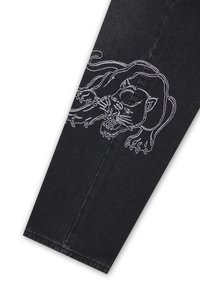 Sort denim bukseben med hvidt broderet omrids af en brølende panter, der strækker sig over stoffet.