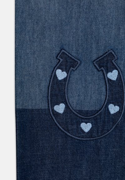 Denim tkanina v različnih odtenkih modre z vezenim temno modrim dizajnom konjske podkve, ki vsebuje svetlo modre srčke ob robu.