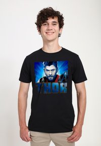Černé bavlněné tričko s výrazným grafickým potiskem Thora modrými akcenty a velkým nápisem "THOR" pod obrázkem.