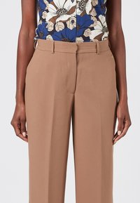 Bruine op maat gemaakte broeken met een rechte snit, gemaakt van gladde stof. Bevat een subtiele voorplooi en discrete zijzakken.