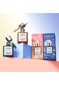 Quatre flacons en verre d'huiles pour le visage avec pipettes : ambre C.E.O. Glow, teal Luna, et deux boîtes à motifs étiquetées Jour + Éclaircir et Nuit + Repulper.