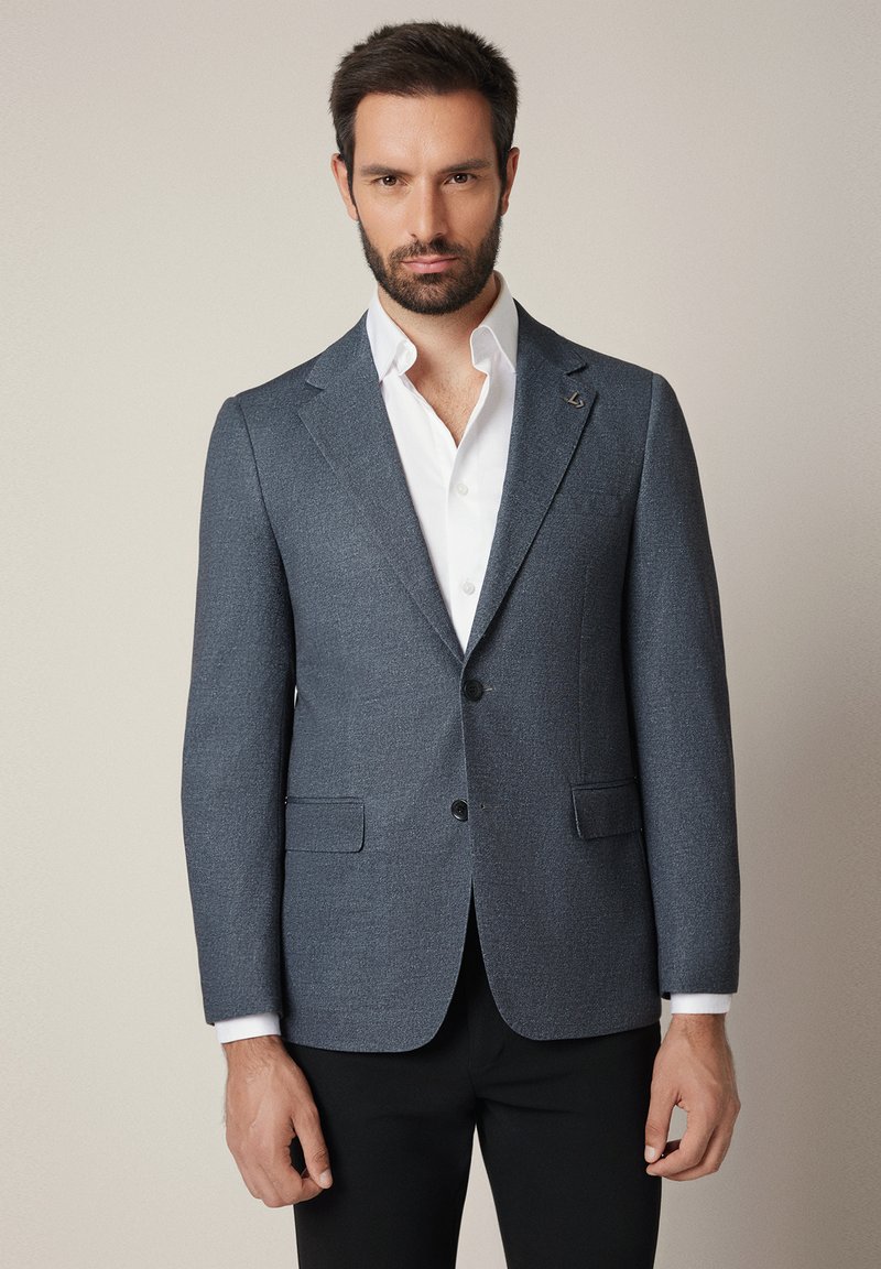 Męska marynarka szyta na miarę w ciemnoszarym kolorze, z wyłogami, dwoma przednimi kieszeniami, zapięciem na jeden guzik oraz gładką strukturą.