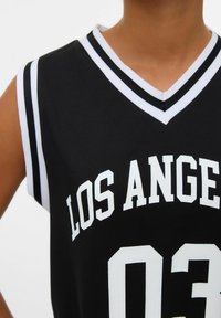 Sort basketballtrøje med hvid tekst, der står "LOS ANGELES" og nummeret "03." Har en V-hals og stribede detaljer på ærmerne.