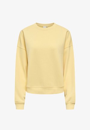 Bluză galben deschis cu mâneci lungi și guler rotund, cu manșete și tiv striate, expusă pe un fundal alb.