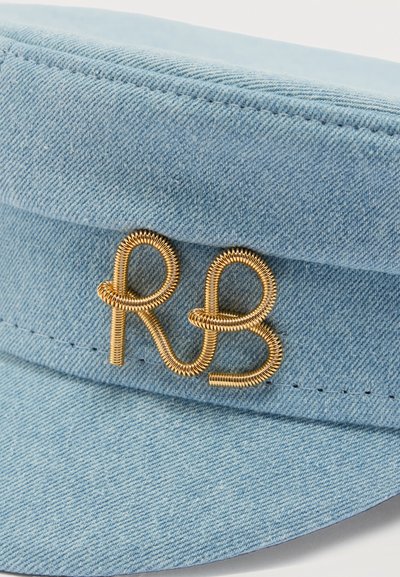 Ανοιχτό μπλε τζιν καπέλο με χρυσή λεπτομέρεια από σύρμα που σχηματίζει τα διαπλεκόμενα γράμματα "R" και "B" στην μπροστινή πλευρά.