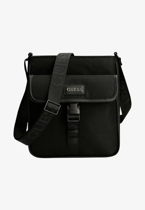 Sac messager noir en tissu texturé avec fermeture à rabat, logo GUESS, bandoulière réglable et accents en métal mat noir.